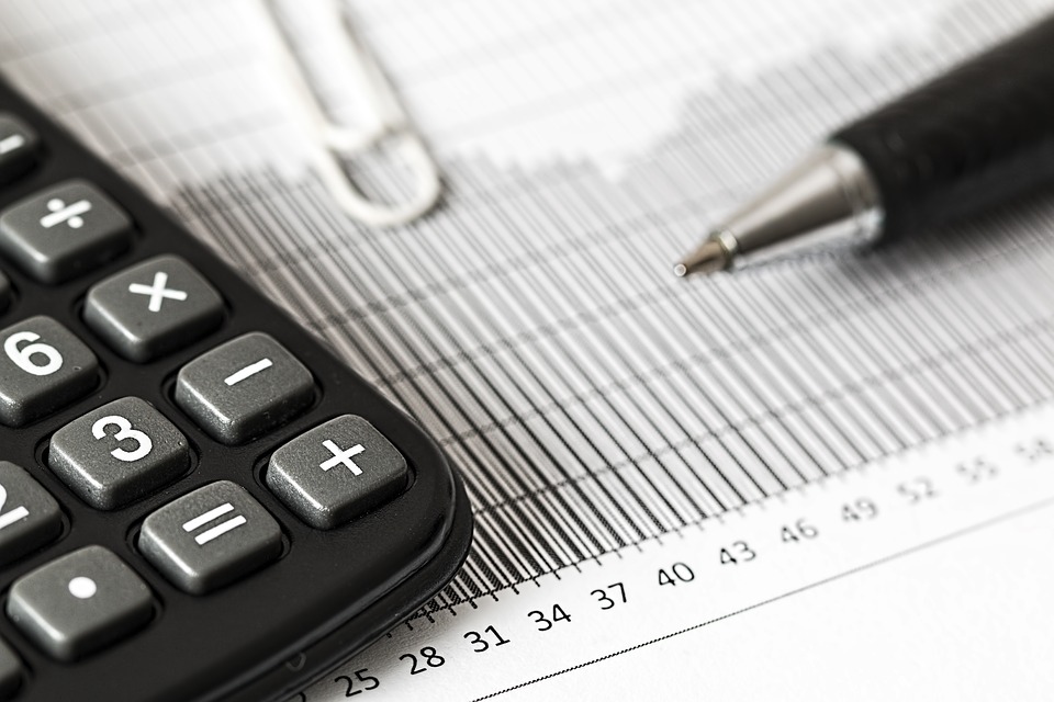 calculator and a pen on top of a report