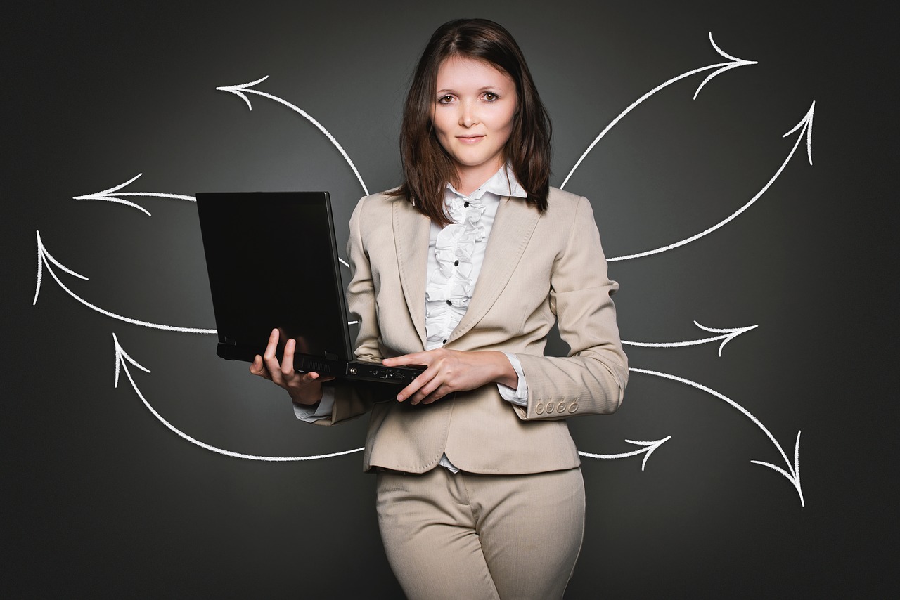 woman in a suit carrying a black laptop